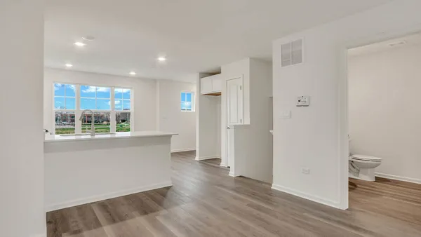a view of a kitchen with wooden floor and a window