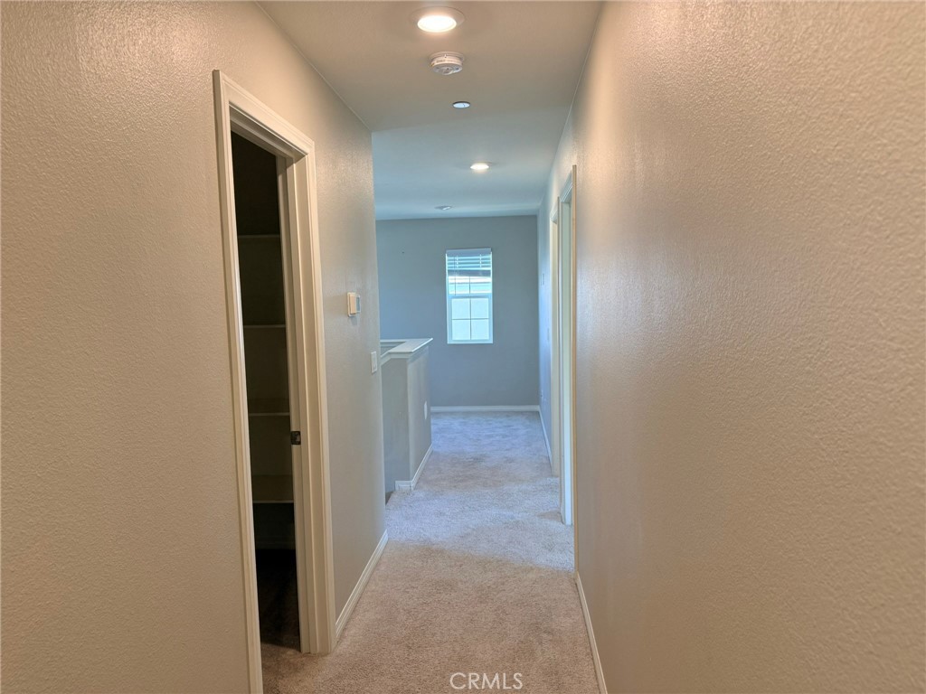 32201 Rambling Court Winchester, CA 92596 - Photo 9 of 11 a view of a hallway with wooden floor and a bathroom