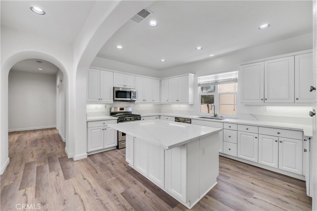 180 Heartwood Way Anaheim, CA 92801 - Photo 11 of 38 a kitchen with white cabinets appliances and sink