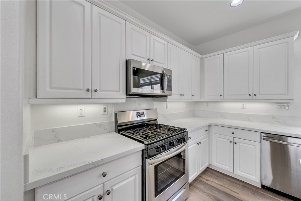 180 Heartwood Way Anaheim, CA 92801 - Photo 15 of 38 a kitchen with white cabinets and appliances