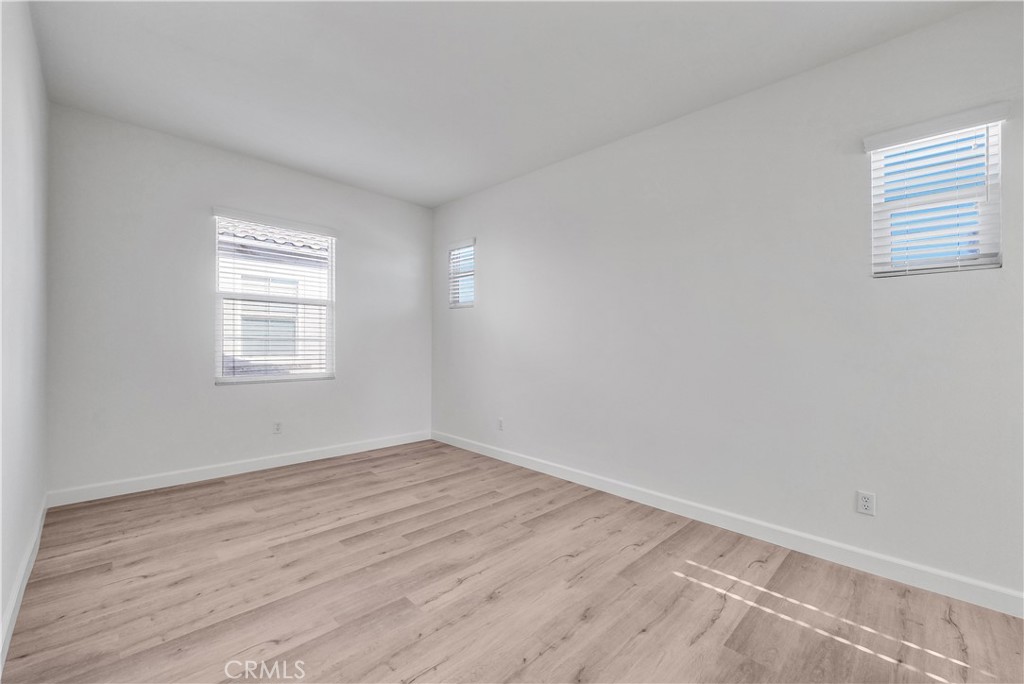 180 Heartwood Way Anaheim, CA 92801 - Photo 23 of 38 a view of an empty room with wooden floor and a window