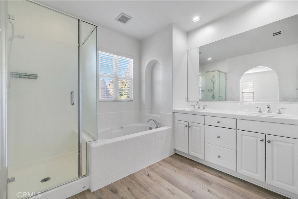 180 Heartwood Way Anaheim, CA 92801 - Photo 32 of 38 a spacious bathroom with a double vanity sink a mirror and a bathtub