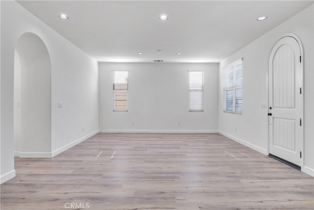 180 Heartwood Way Anaheim, CA 92801 - Photo 7 of 38 a view of an empty room with wooden floor and window