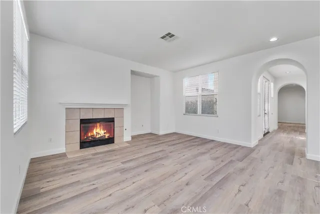 a view of an empty room with a window and fireplace
