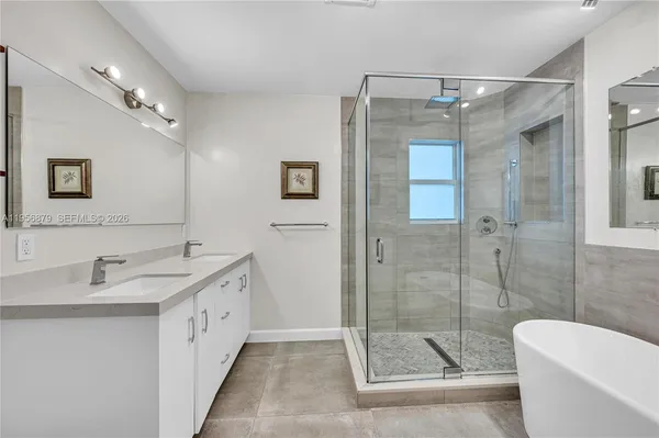 a bathroom with a double vanity sink toilet and shower