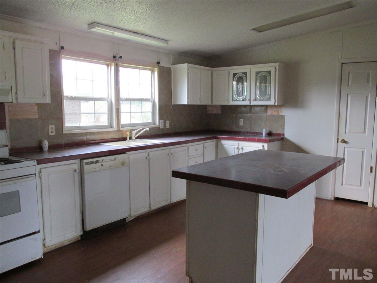 8617 Walter Myatt Road Willow Spring, NC 27592 - Photo 14 of 22 a kitchen with a sink a window and cabinets