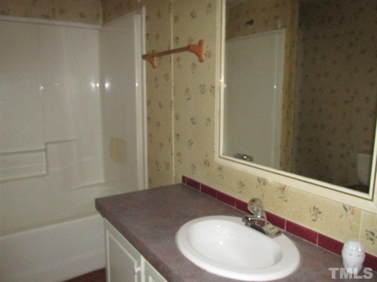 8617 Walter Myatt Road Willow Spring, NC 27592 - Photo 19 of 22 a bathroom with a sink and a mirror
