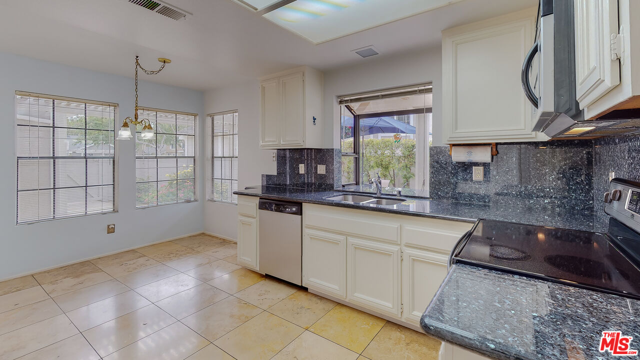 17 Firestone Irvine, CA 92614 - Photo 24 of 75 a kitchen with stainless steel appliances granite countertop a sink a stove a refrigerator and cabinets