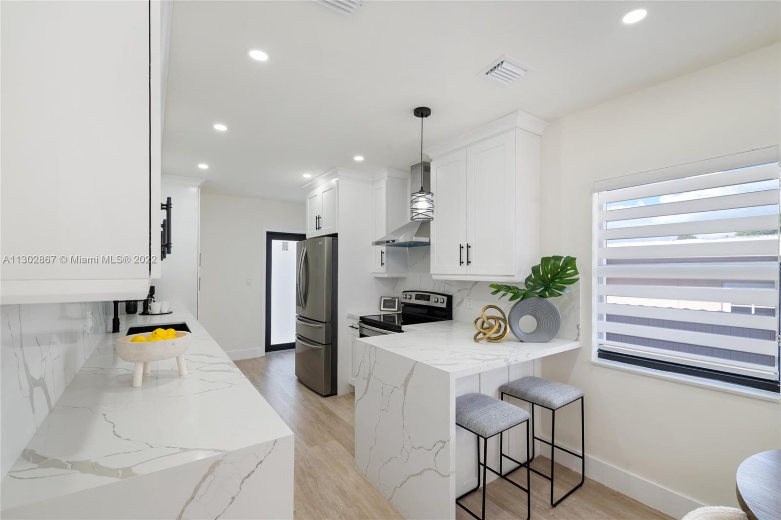 2324 Southwest 58th Court Miami, FL 33155 - Photo 8 of 25 a kitchen with stainless steel appliances kitchen island granite countertop a sink and a refrigerator