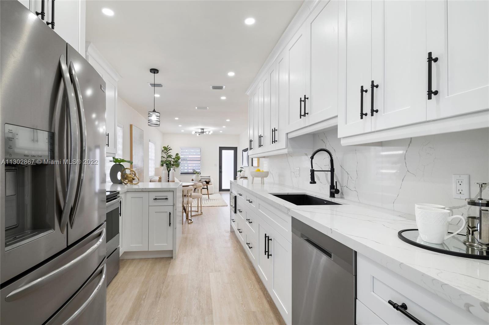 2324 Southwest 58th Court Miami, FL 33155 - Photo 10 of 25 a kitchen with stainless steel appliances a sink stove and cabinets
