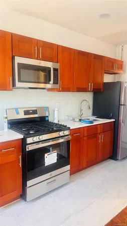 a kitchen with stainless steel appliances granite countertop a stove a sink and a microwave
