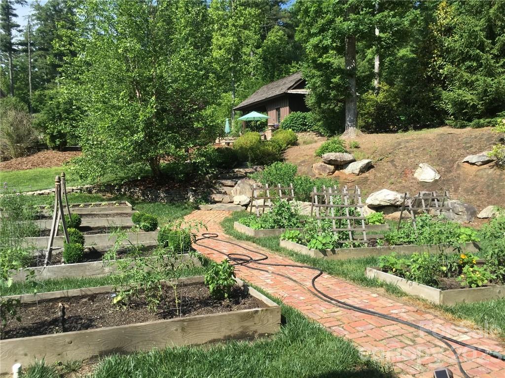 99 Mullally Drive Flat Rock, NC 28731 - Photo 43 of 48 a view of a garden with a bench under an umbrella