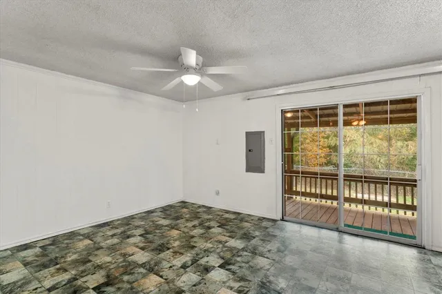 an empty room with a ceiling fan and a window