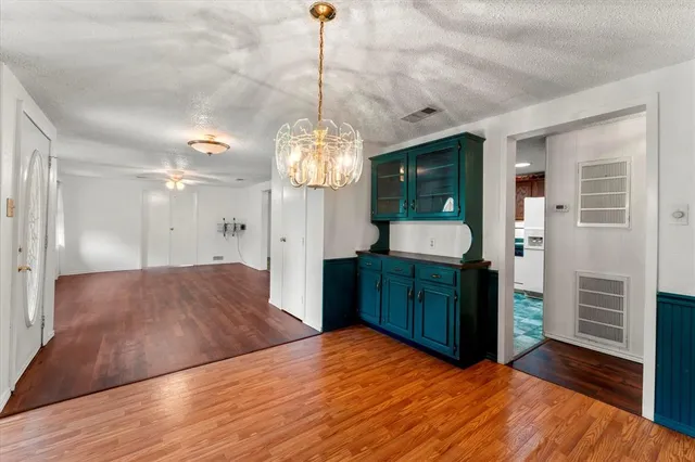 a spacious bedroom with a bed and a dresser