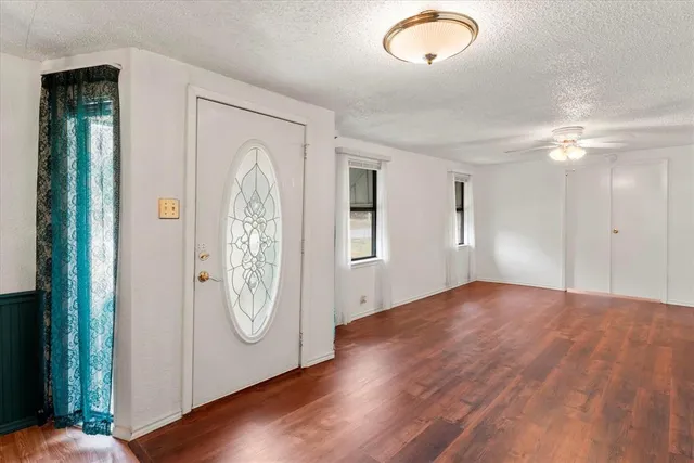 a view of an empty room with closet and wooden floor