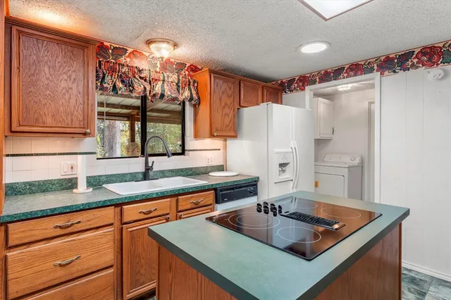 a kitchen with stainless steel appliances granite countertop a sink and a refrigerator