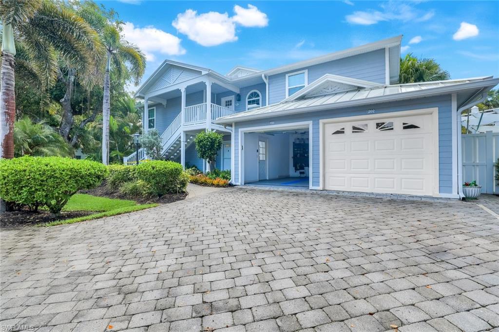 376 3rd Street South, Unit 102 Naples, FL 34102 - Photo 2 of 17 View of front facade with decorative driveway, stairway, and a garage