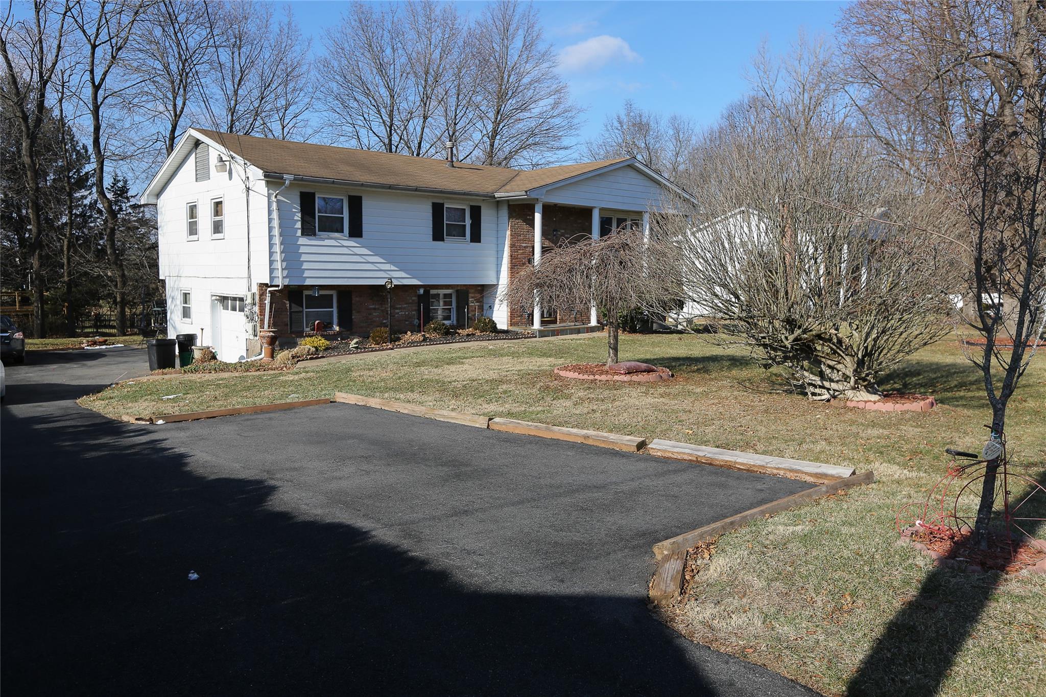 View of front of home with with tenant parking spot and a front yard