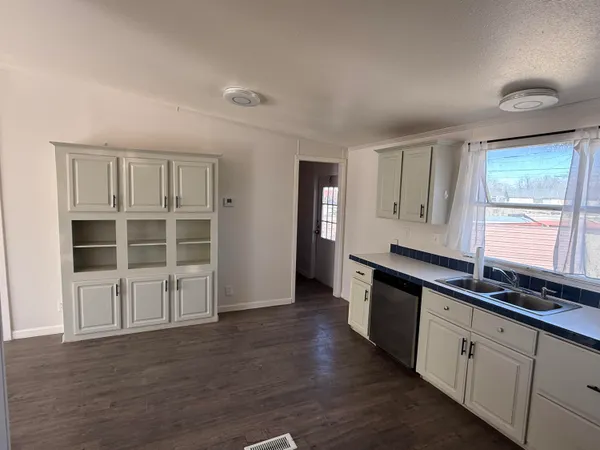 a view of a kitchen with wooden floor and a window