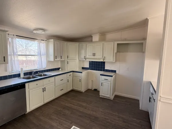 a kitchen with granite countertop white cabinets and white appliances