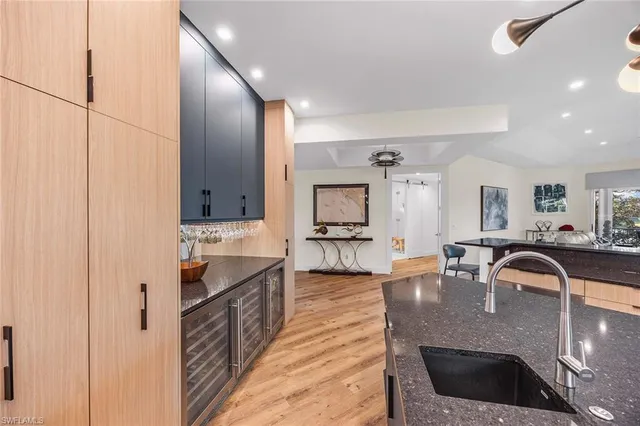 a kitchen with kitchen island granite countertop a sink and cabinets