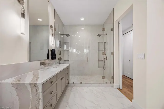 a bathroom with a granite countertop sink mirror and shower
