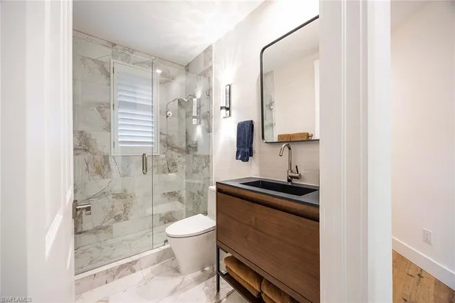 a bathroom with a sink a toilet and shower