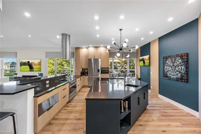 a kitchen with stainless steel appliances granite countertop a sink and a refrigerator