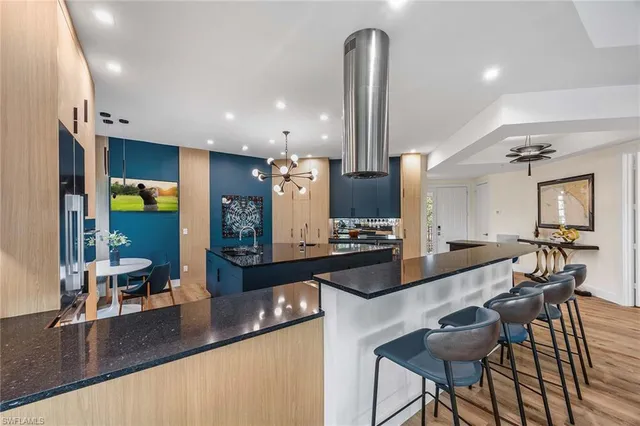 a kitchen with stainless steel appliances kitchen island granite countertop a stove a sink and a refrigerator