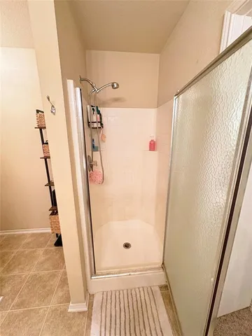 a bathroom with a glass door shower and a sink