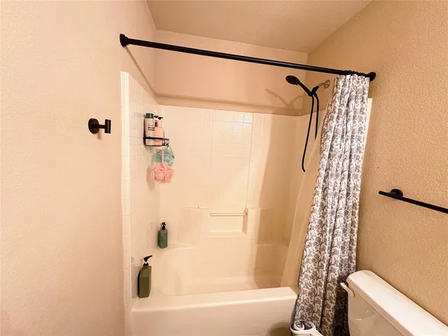 a bathroom with a shower curtain and a toilet