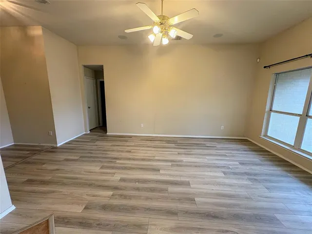 a view of a room with wooden floor and a ceiling fan