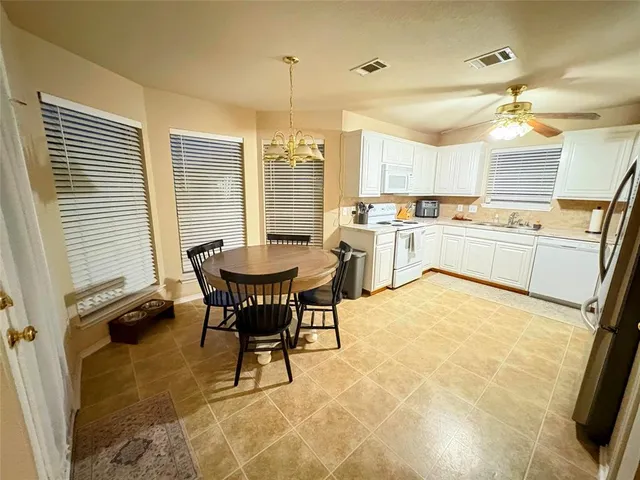 a kitchen with a stove a refrigerator and a table