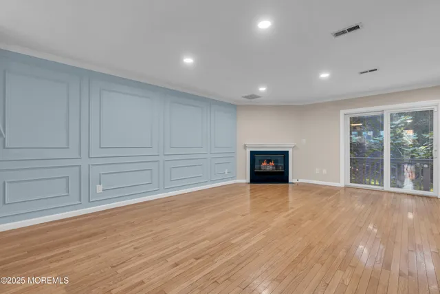 a view of empty room with wooden floor and entryway