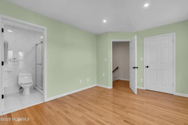 a view of a room with wooden floor and a bathroom