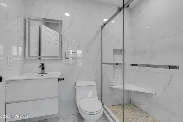 a bathroom with a sink a toilet and shower