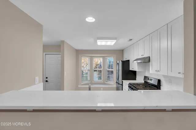 a view of kitchen with sink and refrigerator