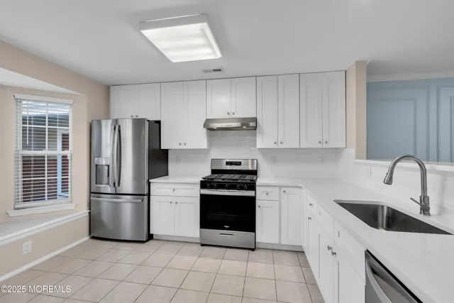 a kitchen with stainless steel appliances granite countertop a refrigerator sink and stove