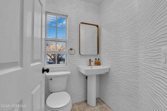 a white toilet sitting next to a bathroom sink