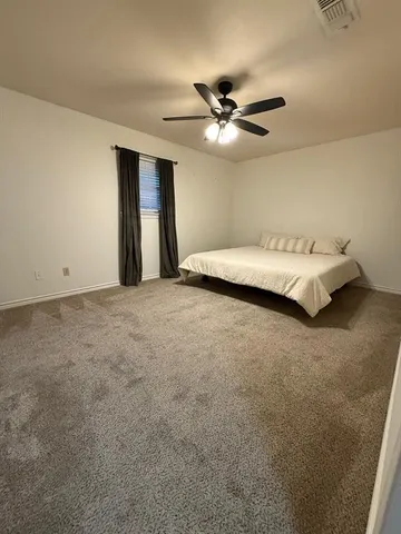 a bed room with a bed and a ceiling fan