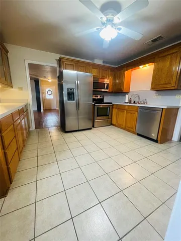 a kitchen with stainless steel appliances granite countertop a sink and a refrigerator