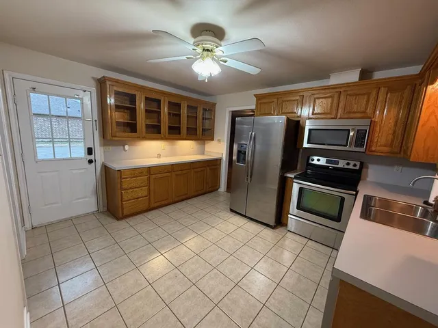 a kitchen with stainless steel appliances granite countertop a refrigerator and a stove top oven