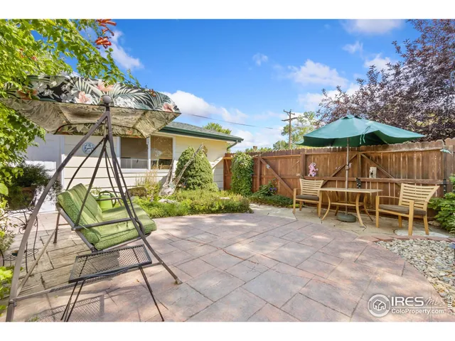 a view of a patio with table and chairs under an umbrella