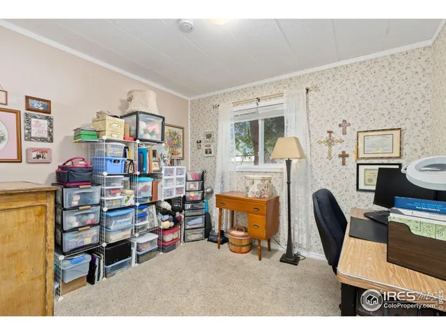 a bedroom with furniture a flat screen tv and a window