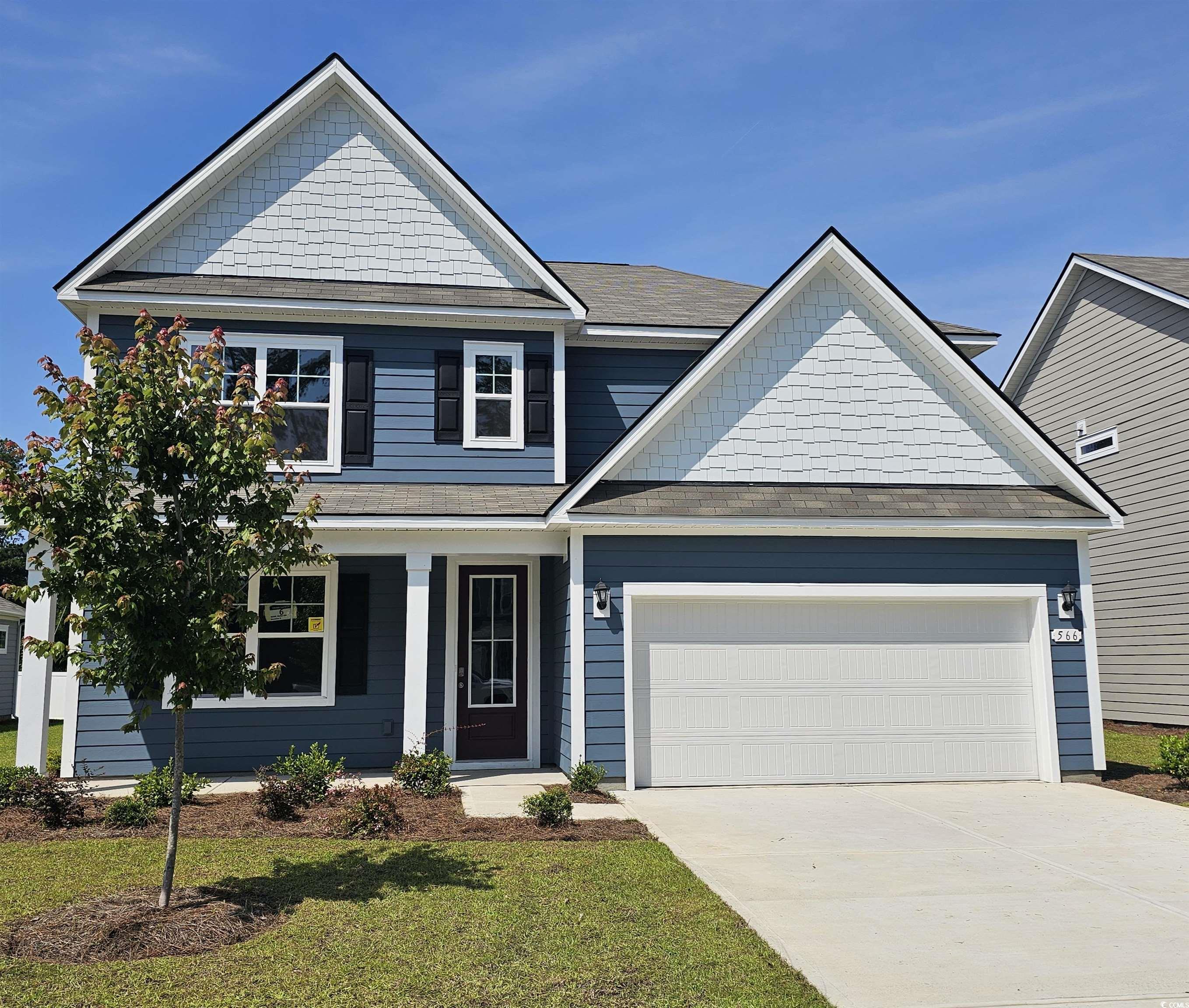 566 Haven View Way Murrells Inlet, SC 29576 - Photo 1 of 24 View of front of house featuring an attached garage, concrete driveway, a front lawn, a porch, and a shingled roof