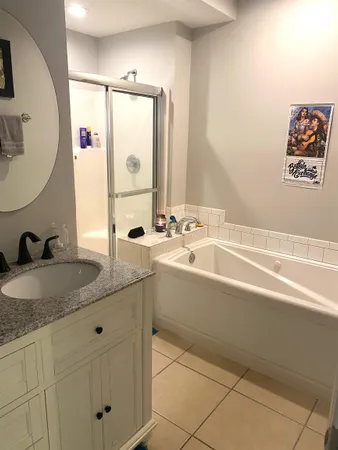 a bathroom with a granite countertop double vanity sink and a mirror