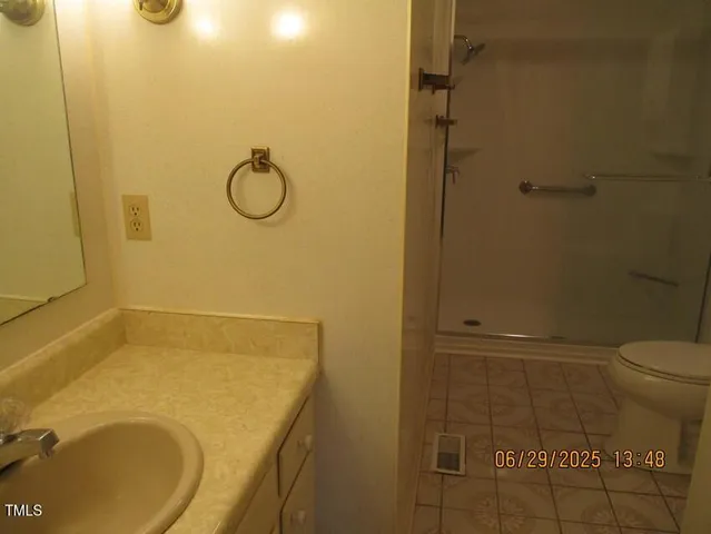 a bathroom with a granite countertop toilet and a sink