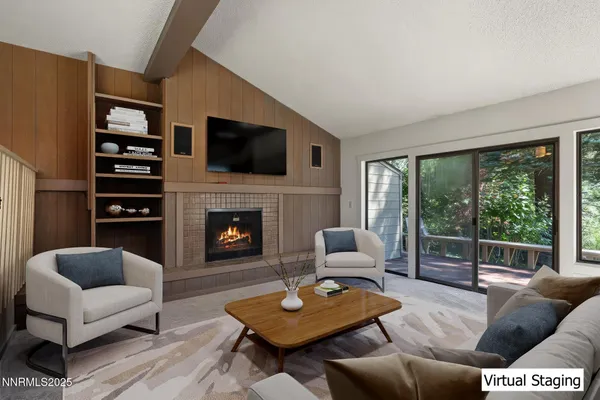 a living room with furniture a fireplace and a floor to ceiling window