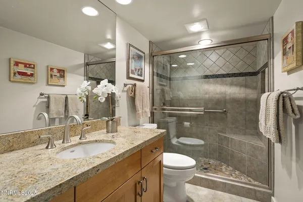 a bathroom with a granite countertop sink toilet and shower
