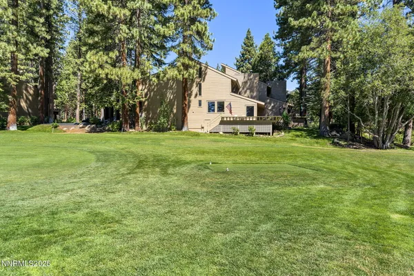 a view of a house with a big yard and large trees